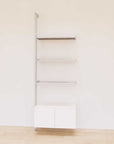 Retail display shelving extension with white shelves, satin vertical post, and base cabinets in a 31-inch, one-bay configuration, shown with open display shelving.