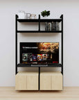 Modular media shelving unit with black shelves and black vertical posts, with Casting Light wood cabinet storage, two bays, shown with open shelf levels.