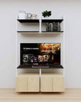 Modular media shelving unit with black shelves and white vertical posts, with Casting Light wood cabinet storage, two bays, shown with open shelf levels.