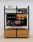 Modular media shelving unit with white shelves and black vertical posts, with Tea for Two wood cabinet storage, two bays, shown with open shelf levels.