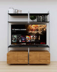 Modular media shelving unit with black shelves and satin vertical posts, with Tea for Two wood cabinet storage, two bays, shown with open shelf levels.