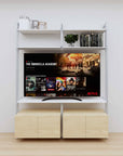 Modular media shelving unit with white shelves and satin vertical posts, with Casting Light wood cabinet storage, two bays, shown with open shelf levels.