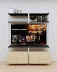 Modular media shelving unit with black shelves and white vertical posts, with Casting Light wood cabinet storage, two bays, shown with open shelf levels.
