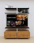 Modular media shelving unit with black shelves and white vertical posts, with Tea for Two wood cabinet storage, two bays, shown with open shelf levels.
