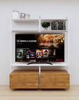 Modular media shelving unit with white shelves and white vertical posts, with Tea for Two wood cabinet storage, two bays, shown with open shelf levels.