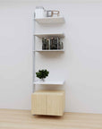 Modular media shelving extension with white shelves and satin vertical post, with Casting Light wood cabinet storage, one bay, 24-inch shelf width, shown with open shelf levels.