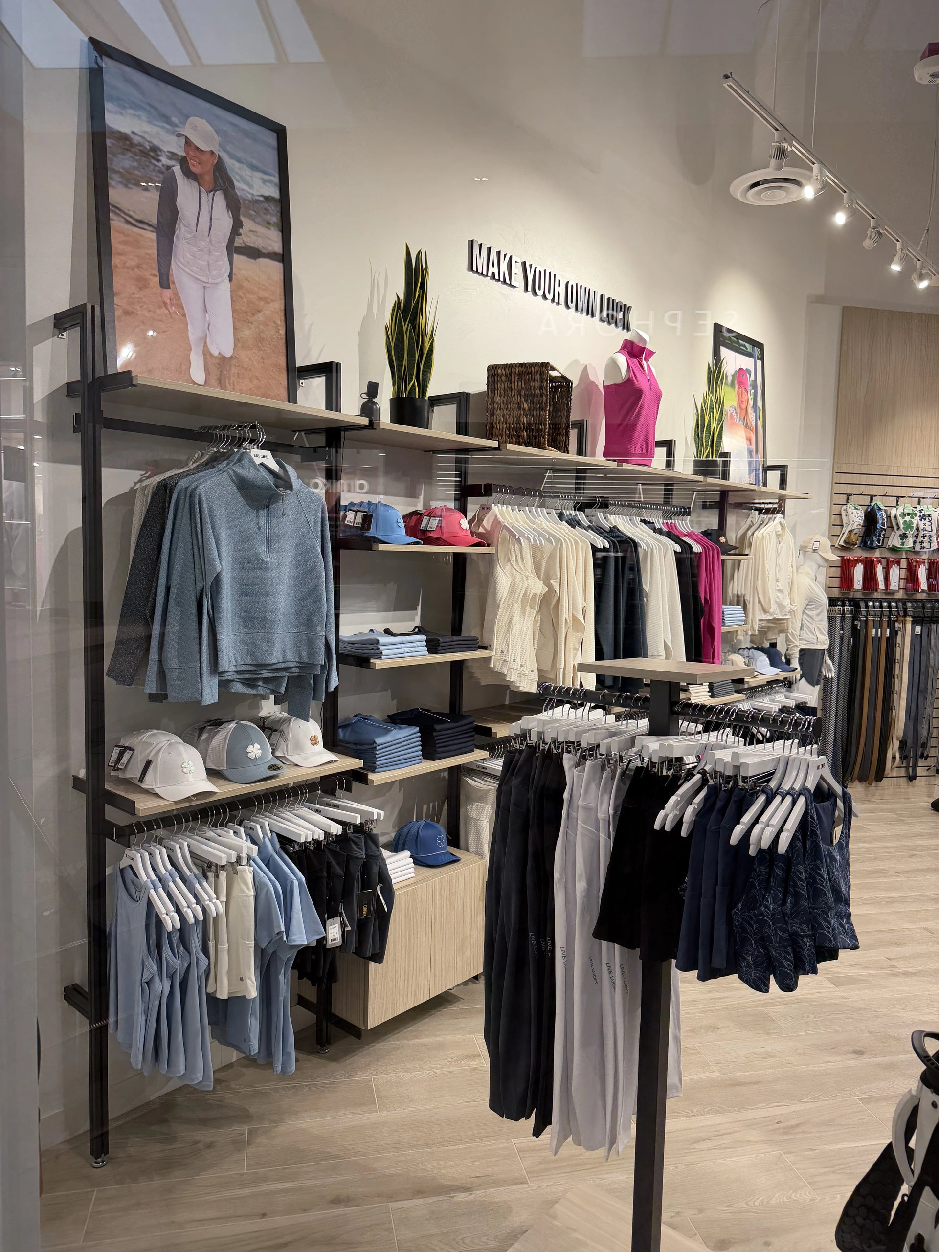 Clothing store interior with racks of clothes and shelves displaying various items.