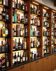 Bottle display shelving unit with black shelves, black vertical posts, and one bay.