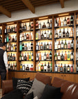 Bottle display shelving unit with black shelves, black vertical posts, and one bay.