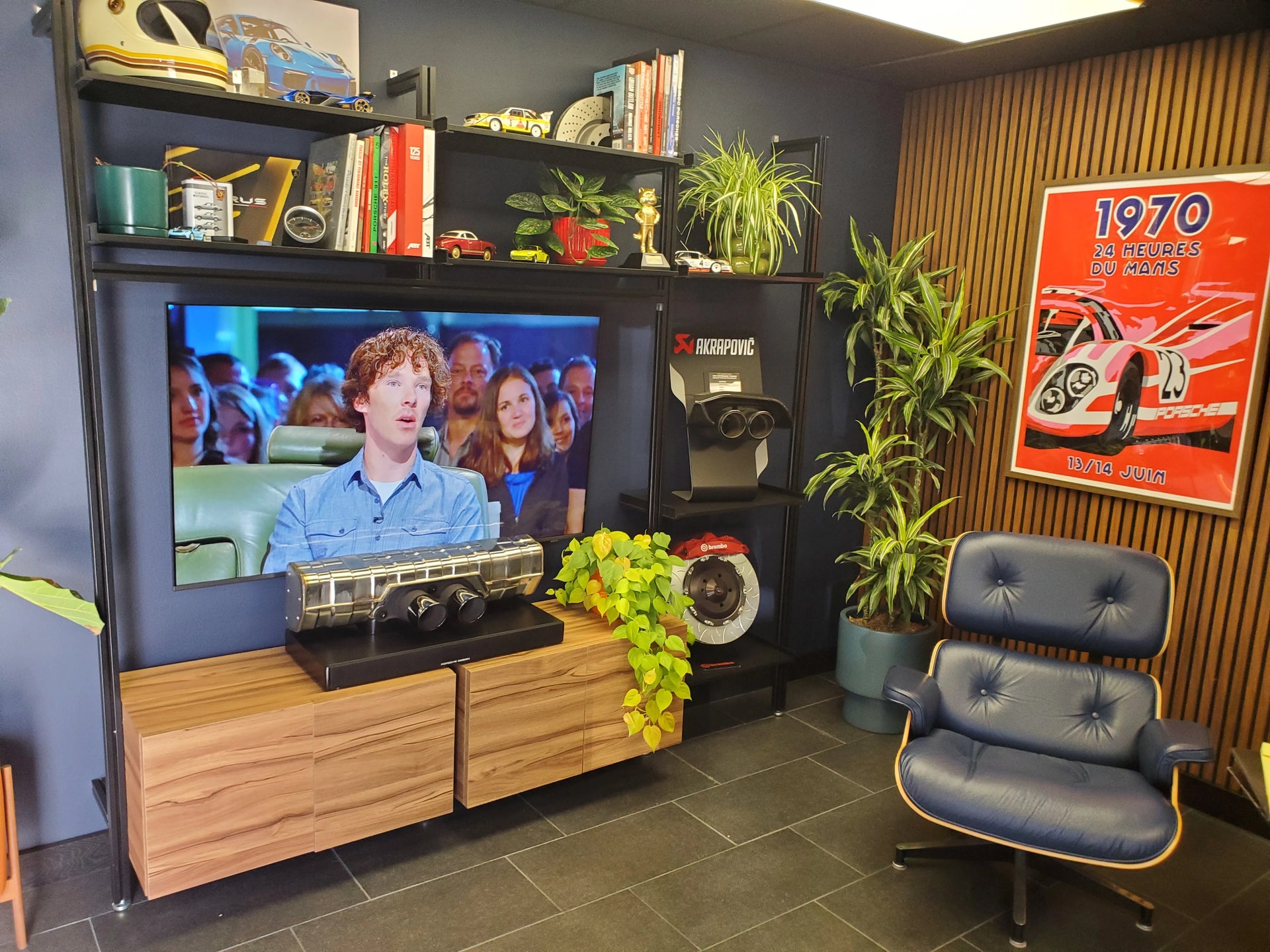 Living room with a TV, shelves, and a chair.